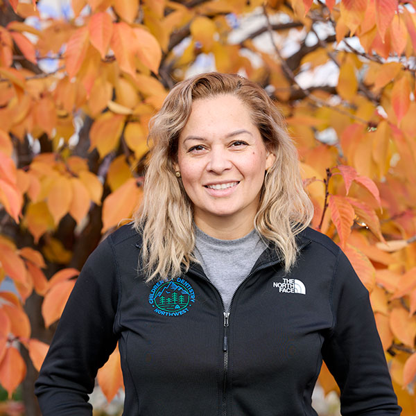 Young Woman Smiling By Green Wall